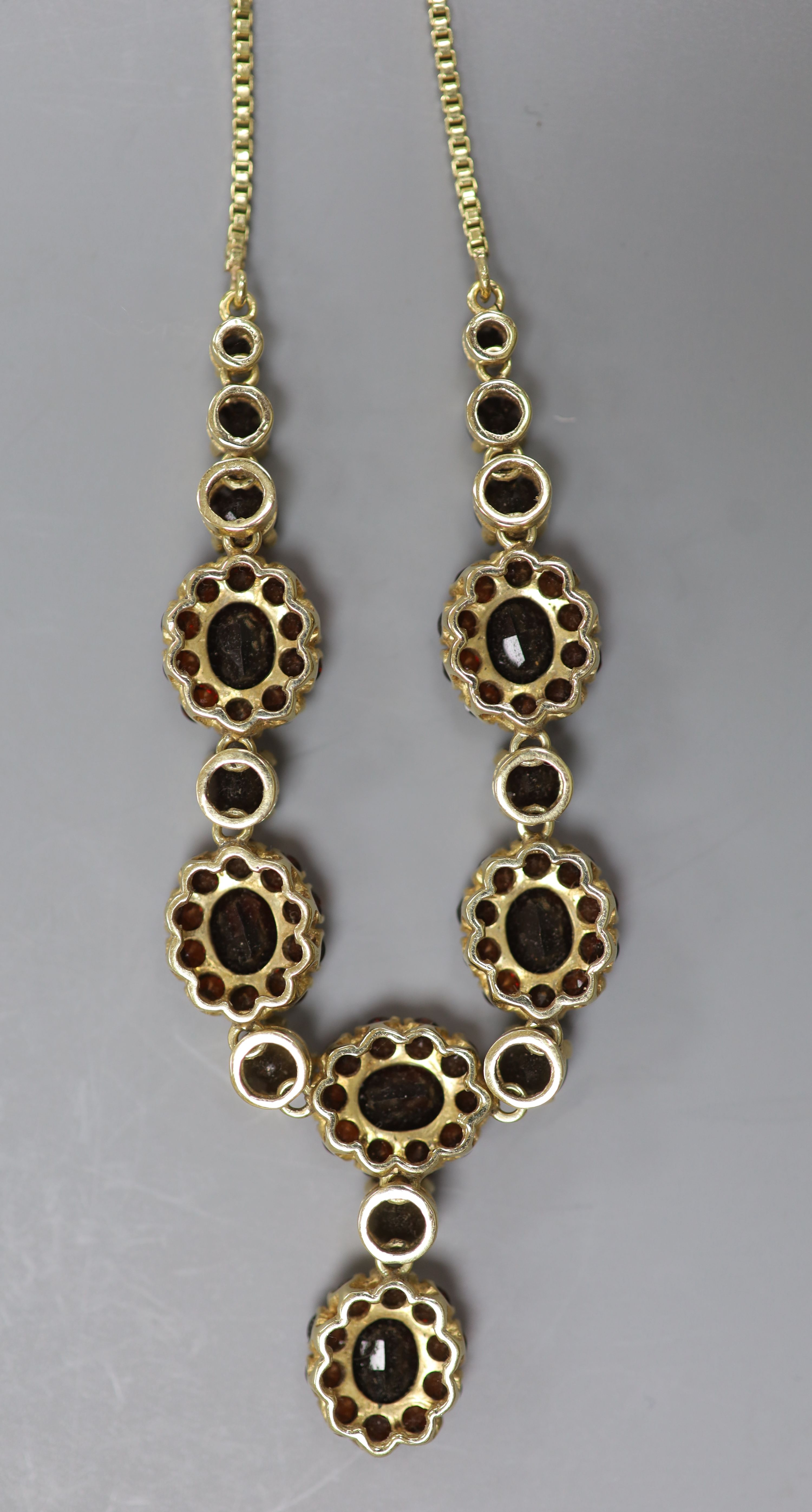 A 20th century 585 yellow metal and garnet cluster set necklace
